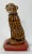 Statuesque handmade ceramic cat seated on red gilded braid pillow. Wonderful hand-painted detail. Unmarked. Hand painted...