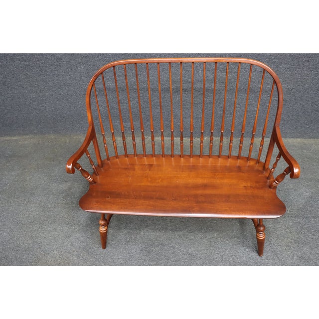 L. Hitchcock Windsor settee bench in a warm cherry finish, featuring an exceptionally tall continuous spindle back, curved...