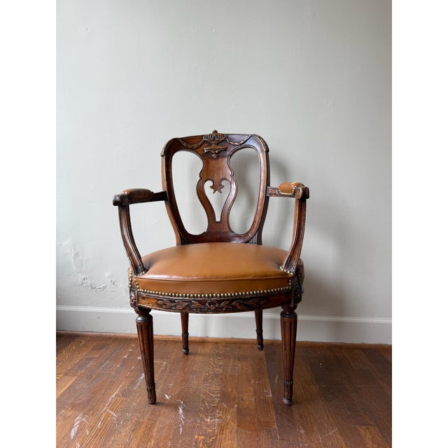 This 19th Century English Armchair features a refined design with clean lines and a sleek leather seat cushion, offering...