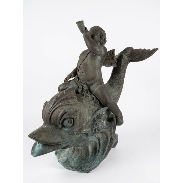 Monumental bronze fountain depicting a classically rendered cherub (putto) riding a stylized dolphin, sourced from a Star...
