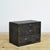 An atmospheric small Japanese tansu—specifically a compact ko-dansu—featuring four drawers. The chest is fitted with...