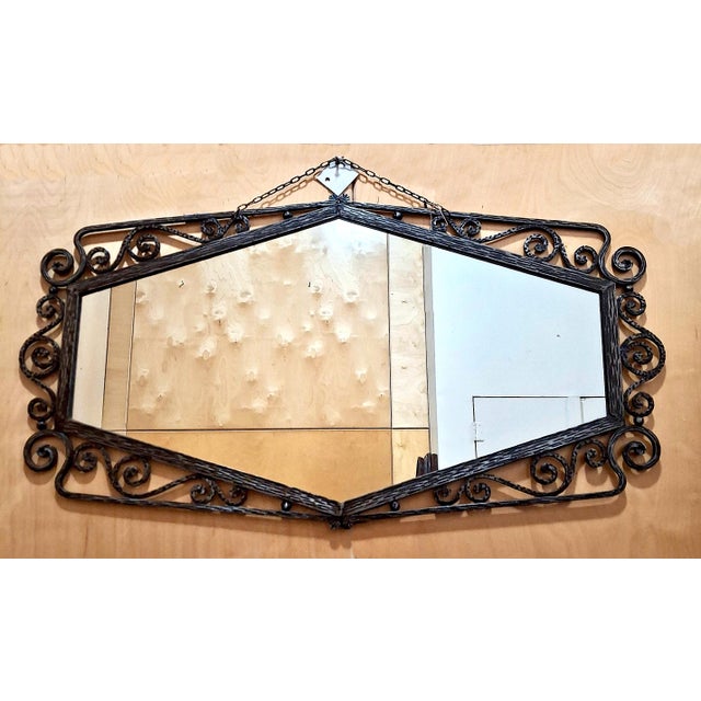This wrought iron mirror is styled in the manner of the preeminent metalworker of the Art Deco period Edgar Brandt...