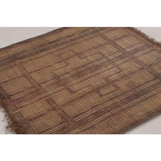 Made with handwoven reed and camel leather in Mauritania circa 1950-1960, this 4x4 vintage square Tuareg mat is an...