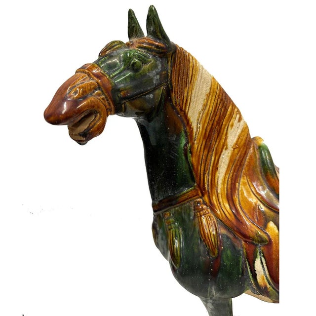A large vintage Tang style Sancai glazed terracotta horse. This exquisite piece features a striking green and brown color...