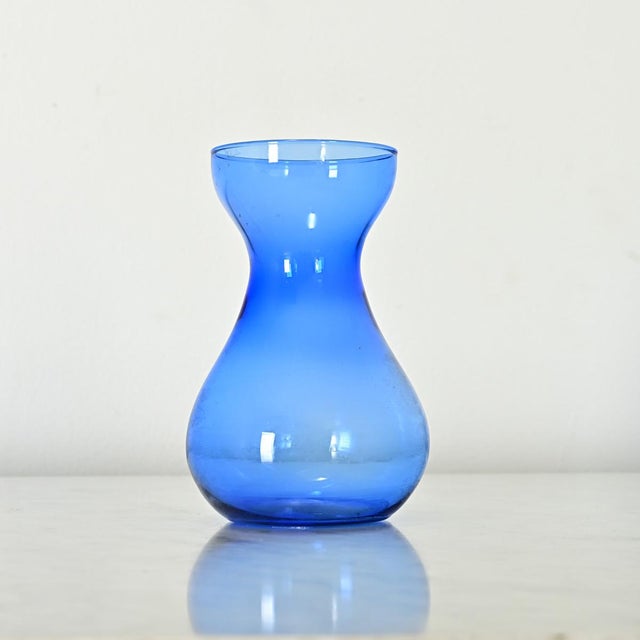 Dimensions: 5 ¾” H x 3 ¼” W x 3 ¼” D Hand rolled glass hyacinth forcing vase from the 1890’s in a stunning indigo blue....