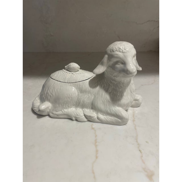 This covered serving dish is in the shape of a resting lamb. The lid which has a lemon as its pull also has a cut out for...