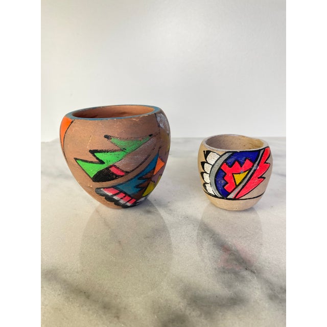 A charming pair of mid-century handmade pottery vessels from Tesuque, New Mexico, decorated in the brightly colored...