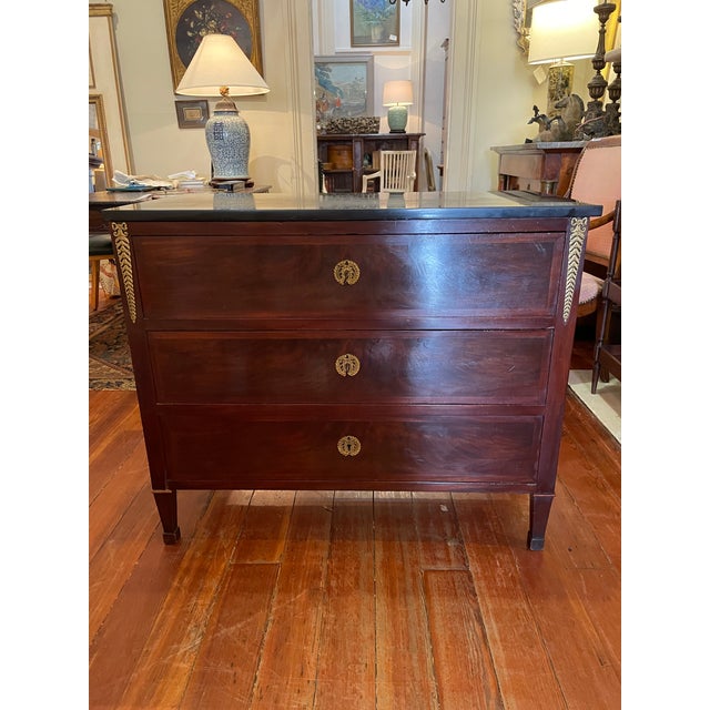 A nicely scaled, petite 19th century French Empire mahogany commode, with a black marble top over three drawers and...