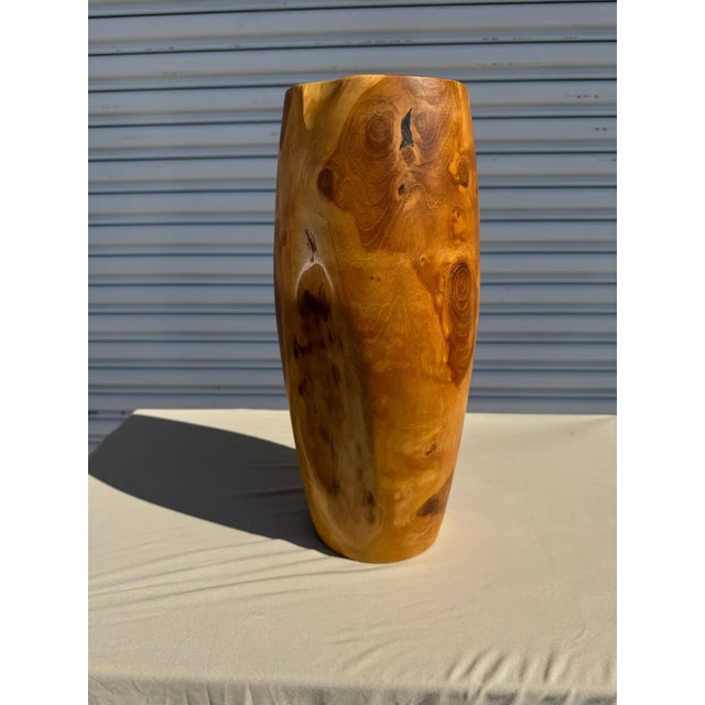 This is a hand turned vase made of the root of a burlwood tree. It stands 15"h and is 7"d.