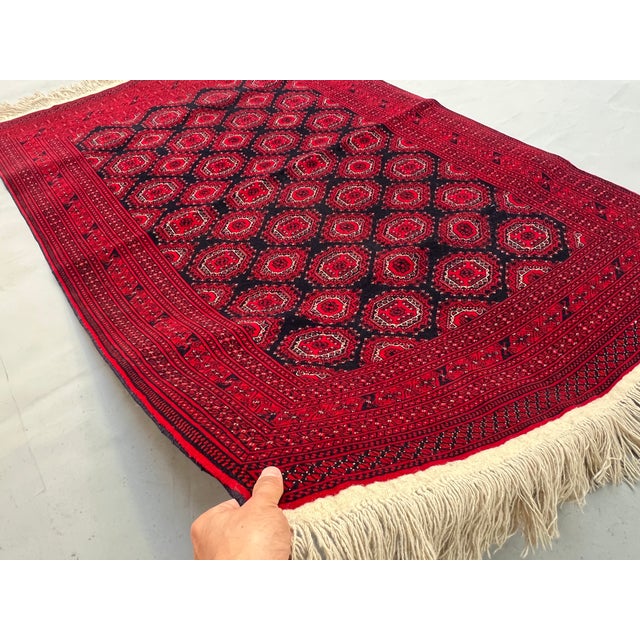 A vintage Afghan Turkmen rug in the classic Royal Bokhara design — rows of quartered octagonal Tekke güls locked in a...