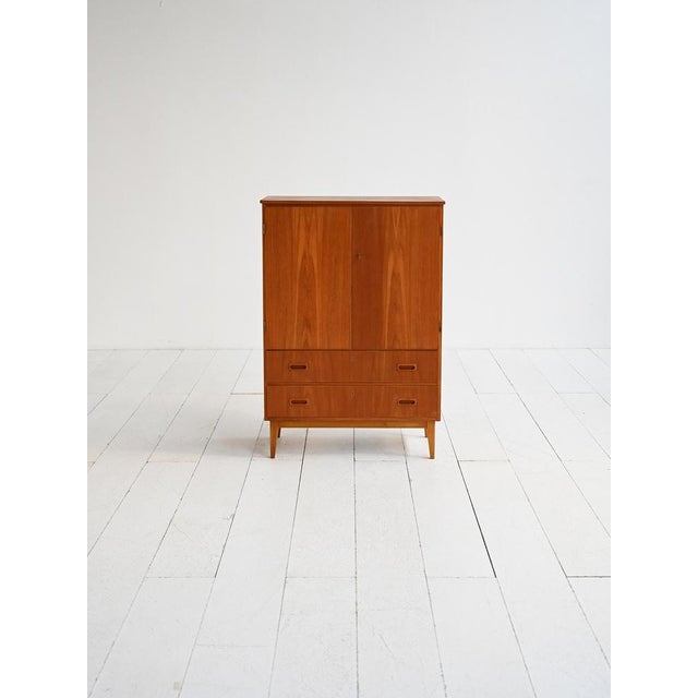 1960s teak veneered cabinet with upper doors and two drawers. This Scandinavian-made cabinet dates back to the 1960s,...