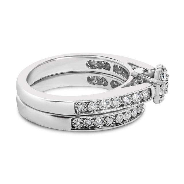 Crafted from the refined sheen of .925 sterling silver, this bridal set features two rings that embrace the essence of...