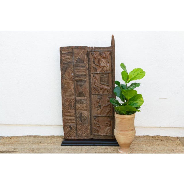 From southwestern Nigeria, this two-plank Yoruba door pairs a geometric panel with a narrative figural panel, the paired...