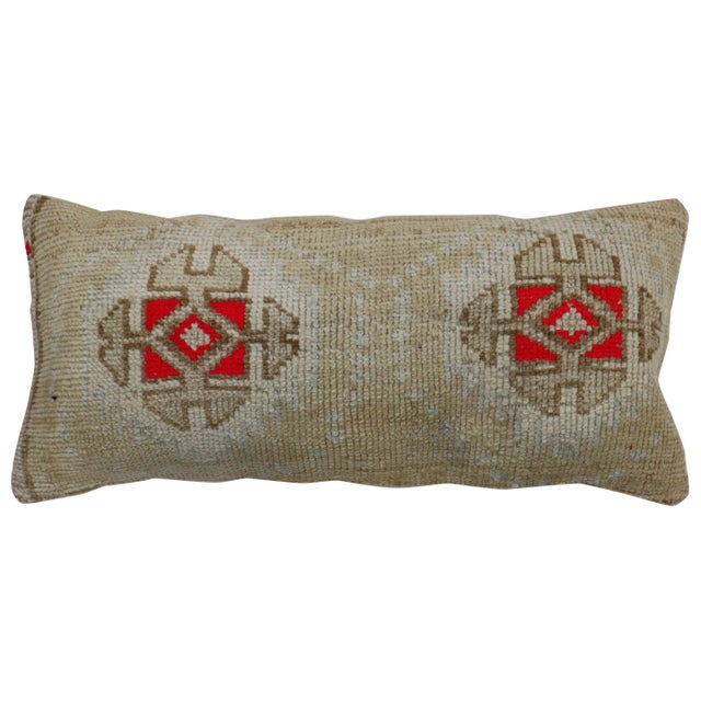 Large bolster size pillow made from a vintage Turkish Anatolian rug. Pops of bright red, outlined by brown medallions and...
