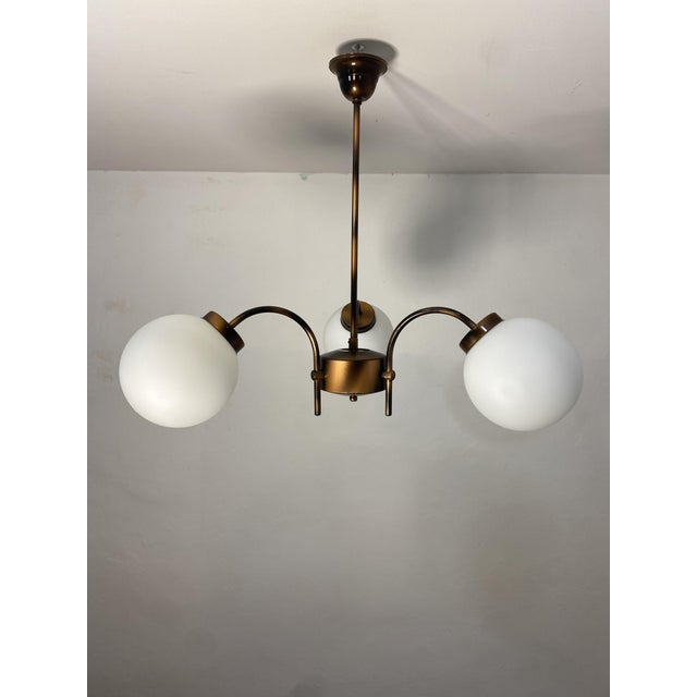 Original vintage chandelier with the manufacturer's KAJ label, Dol pri Hrastniku, Slovenia. Featuring three white opaline...