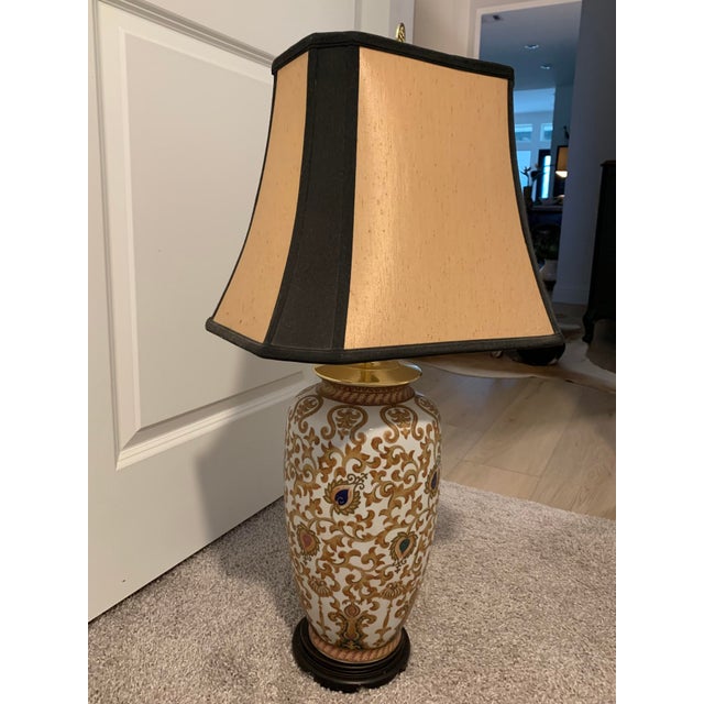 Offering a lovely gold and black patterned ceramic lamp with Asian brass finial. Included is a black and gold bell shaped...