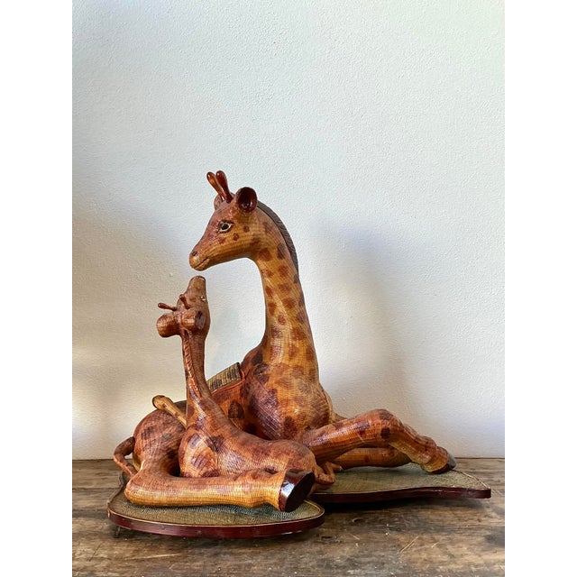 This charming vintage sculpture captures a heartwarming scene of a mother giraffe and her calf, masterfully crafted using...