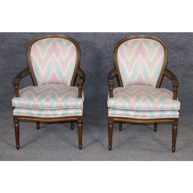 This refined pair of French style Louis XVI walnut armchairs, crafted in the mid-20th century, carries forward the...