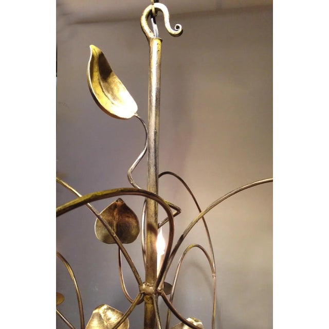 Beautifully hand-wrought fixture is hand-finished in gold and charcoal grey. Perfect for over a dining table, in a master...