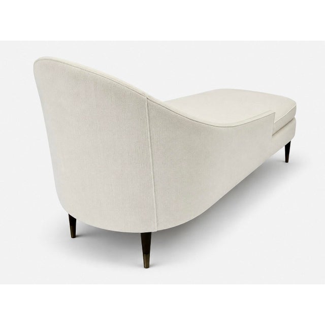 Defined by its graceful asymmetrical silhouette, the chaise features a sculptural wraparound back that flows into a single...