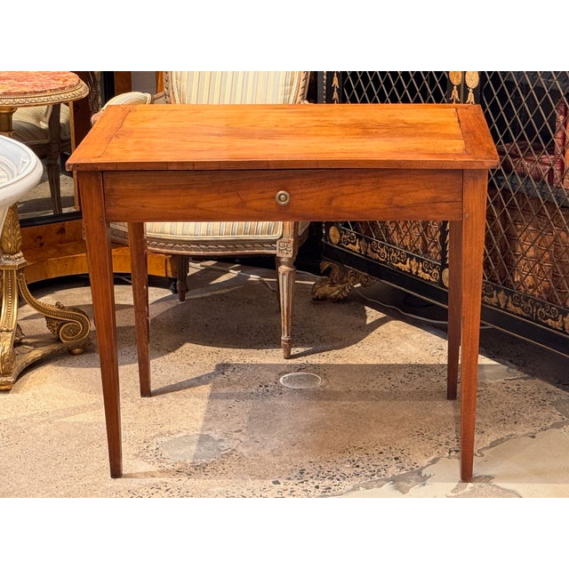 A 19th century French cherry table with a rectangular top set above a single drawer. Constructed in cherry with a framed...