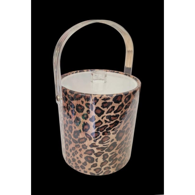 A nice vintage vinyl leopard ice bucket. The bucket features a lucite handle with a coated leopard vinyl design. It's a...