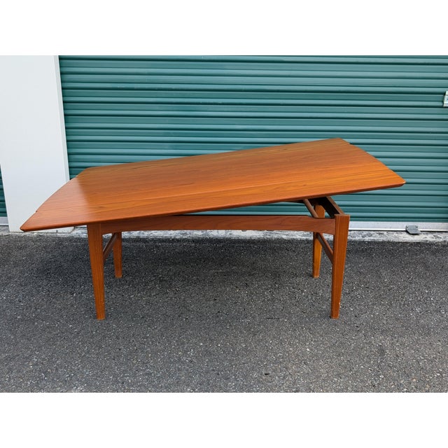 A very stylish and practical modern teak and teak veneer coffee / dining table with a unique mechanism. Hidden leaves and...