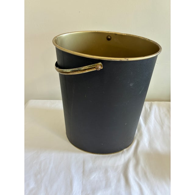 Vintage Mid-Century wastebasket featuring a textured matte black exterior with brass-tone interior and matching metal...