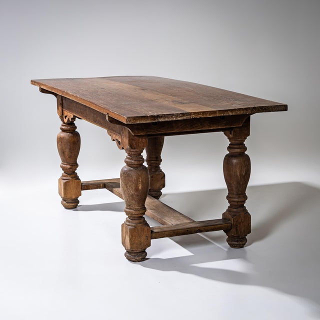 Rectangular oak dining table with baluster legs and an H-shaped stretcher between the legs. The aprons are plain, adorned...