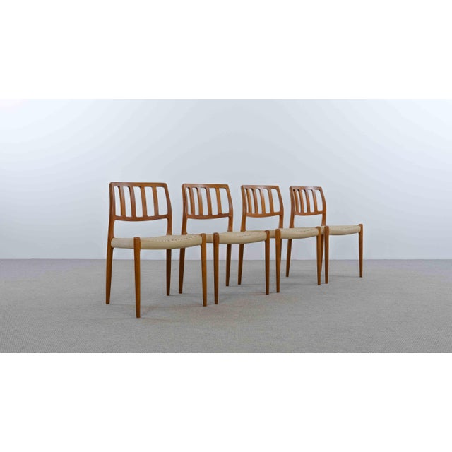 An elegant set of four iconic Model 83 dining chairs by renowned Danish designer Niels Otto Møller. These chairs were...