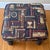 Handsome rustic carved foot stool, upholstered in a cluttered-library themed upholstery. Please see condition details...