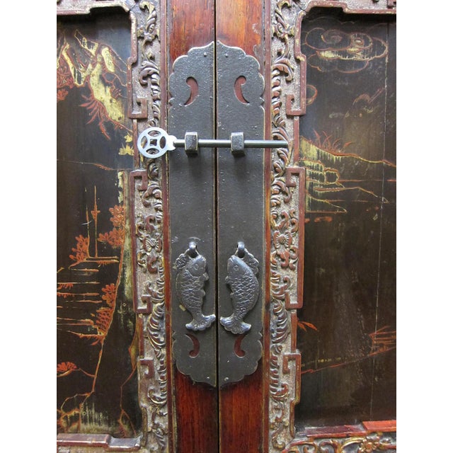 19th century Chinese cabinet with carved panels and painting. From Anhui province this cabinet is made of fir wood and...