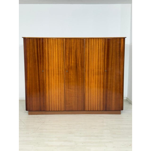Impressive wardrobe in a mid-century design. This piece of furniture captivates with its generous proportions, exceptional...