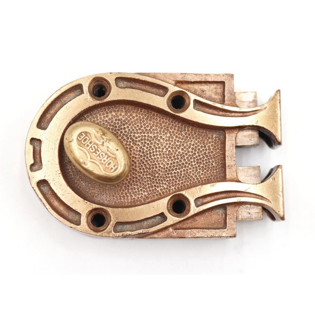 Deadbolt rim lock that features a horseshoe frame. The oval turn knob is stamped with "HORSESHOE" text. The catch is not...