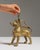 This 19th century brass lion aquamanile oil lamp is cast in brass as a standing lion with a ring handle on its back. The...