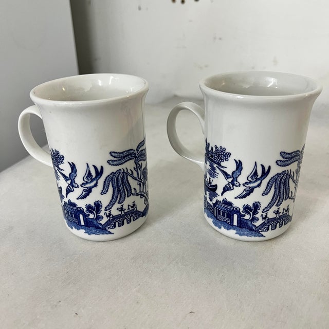 A set of three one Churchhill, made in Romani, Blue Willow teapot and two, made in England, blue willow mugs. Teapot...