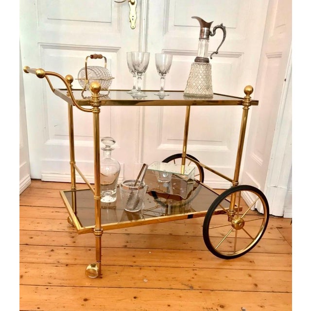 Elegant mid-century brass coffee table or side table from the 1960s or 70s with two tinted crystal glass tops on casters,...
