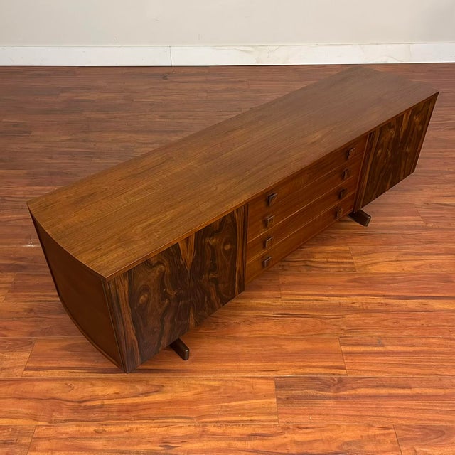 Vintage trestle base teak and rosewood sideboard with sides that are slightly curved outwards, giving it a cool and unique...