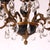 An antique French Empire chandelier offers ebonized and gilt metal frame with scroll and foliate elements, hanging cut...