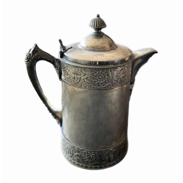 Meridien Silver Company water pitcher, lined in white enamel. Intricate design with Assyrian faces. Substantial and well...