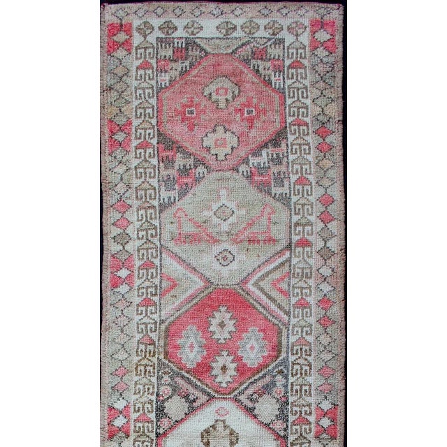 Vintage Oushak runner from Turkey with Vertical Medallion design in multi-colors, charcoal, pink, red, and cream. Keivan...