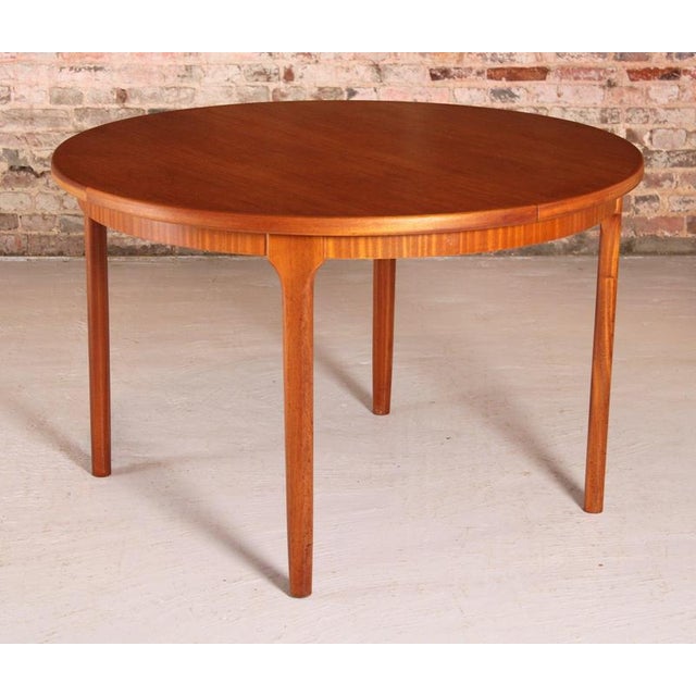 Mid century round extending teak dining table by mcintosh, circa 1970s. A butterfly extension leaf stored underneath....