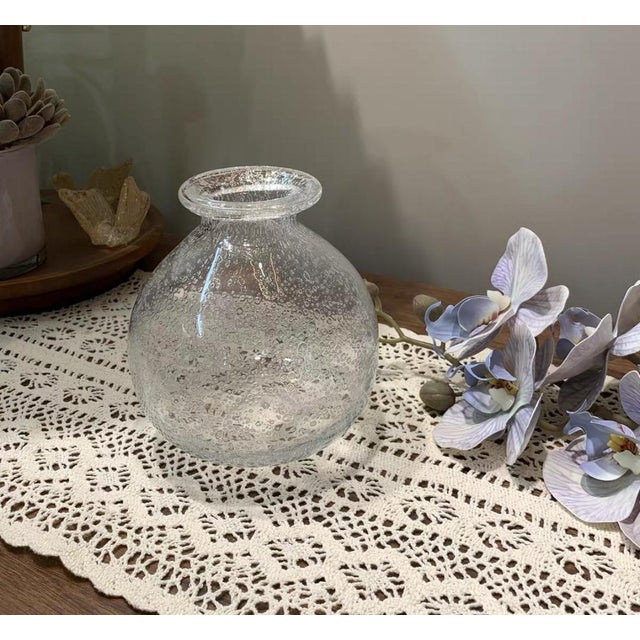 This is a handmade glass bubble vase with delicate irregular air pockets on the surface. The circular narrow neck design...