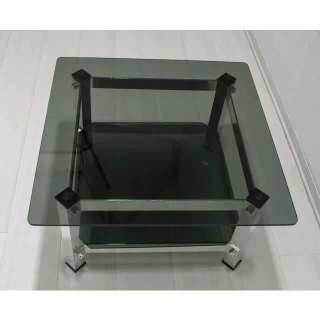 - Table produced in Italy in the '70s - In aluminum and dark green glass - It has two shelves