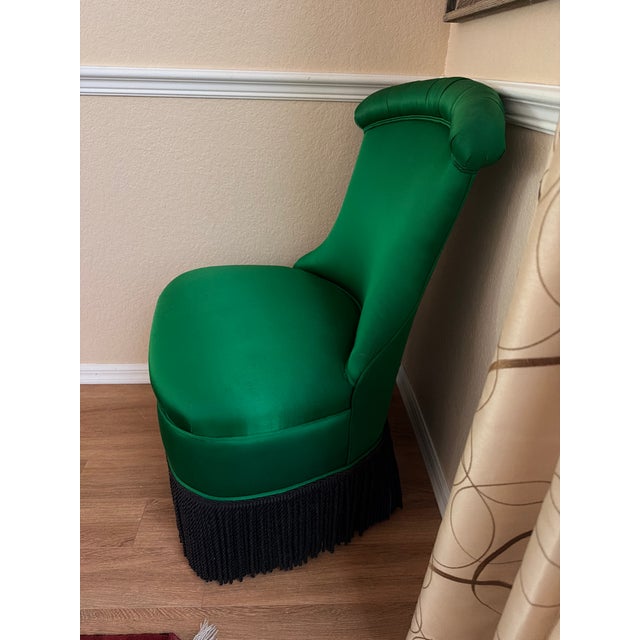This striking piece is a Hollywood Regency style "Draper" slipper chair featuring a bold emerald green satin finish and a...