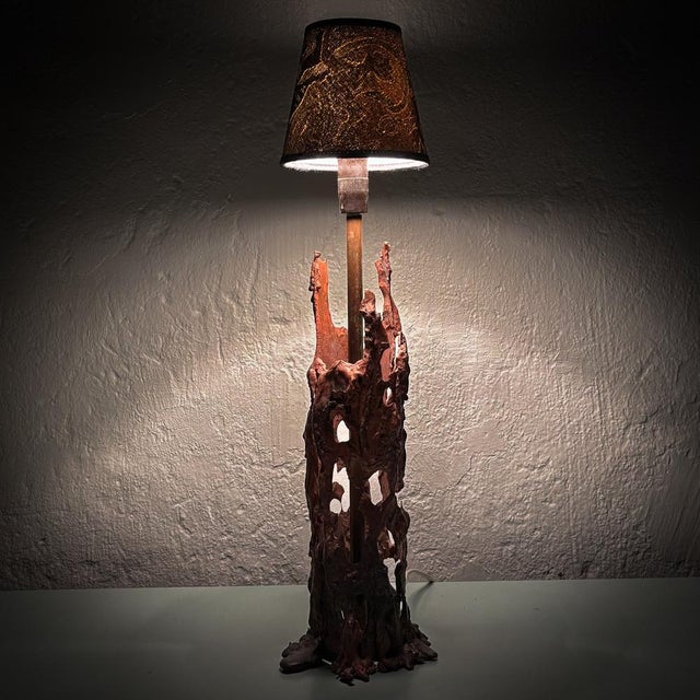 A sculptural, handcrafted Scandinavian brutalist table lamp, constructed from partially melted copper. The lamp holder is...