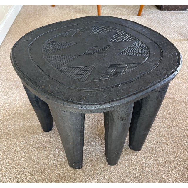 Senufo stools are never figural but have abstract and geometric patterns integrated into their design. The table has...