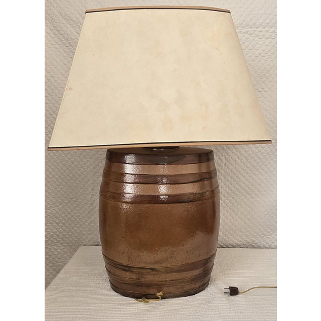 This antique table lamp is crafted from an early stoneware whiskey barrel, later professionally converted for electric...