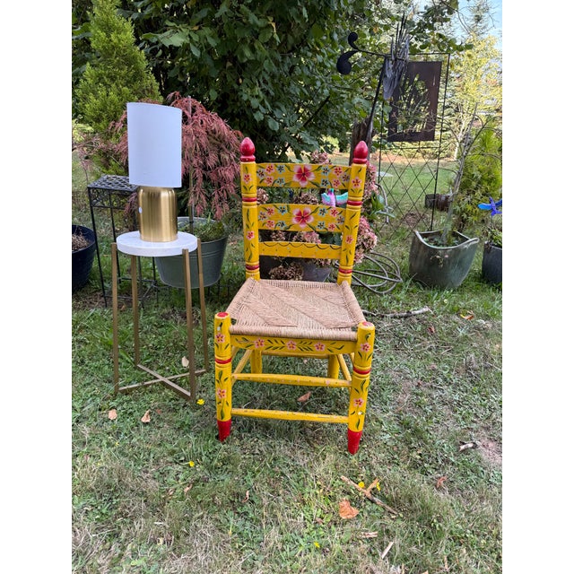 Charming vintage wooden side chair featuring vibrant colours and a traditional handwoven rush/fiber seat give this chair a...