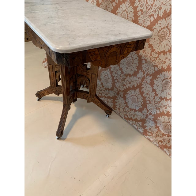 Here we have a fabulous antique Victorian parlor table. This beauty has a marble top, porcelain wheels, wonderful spoon...